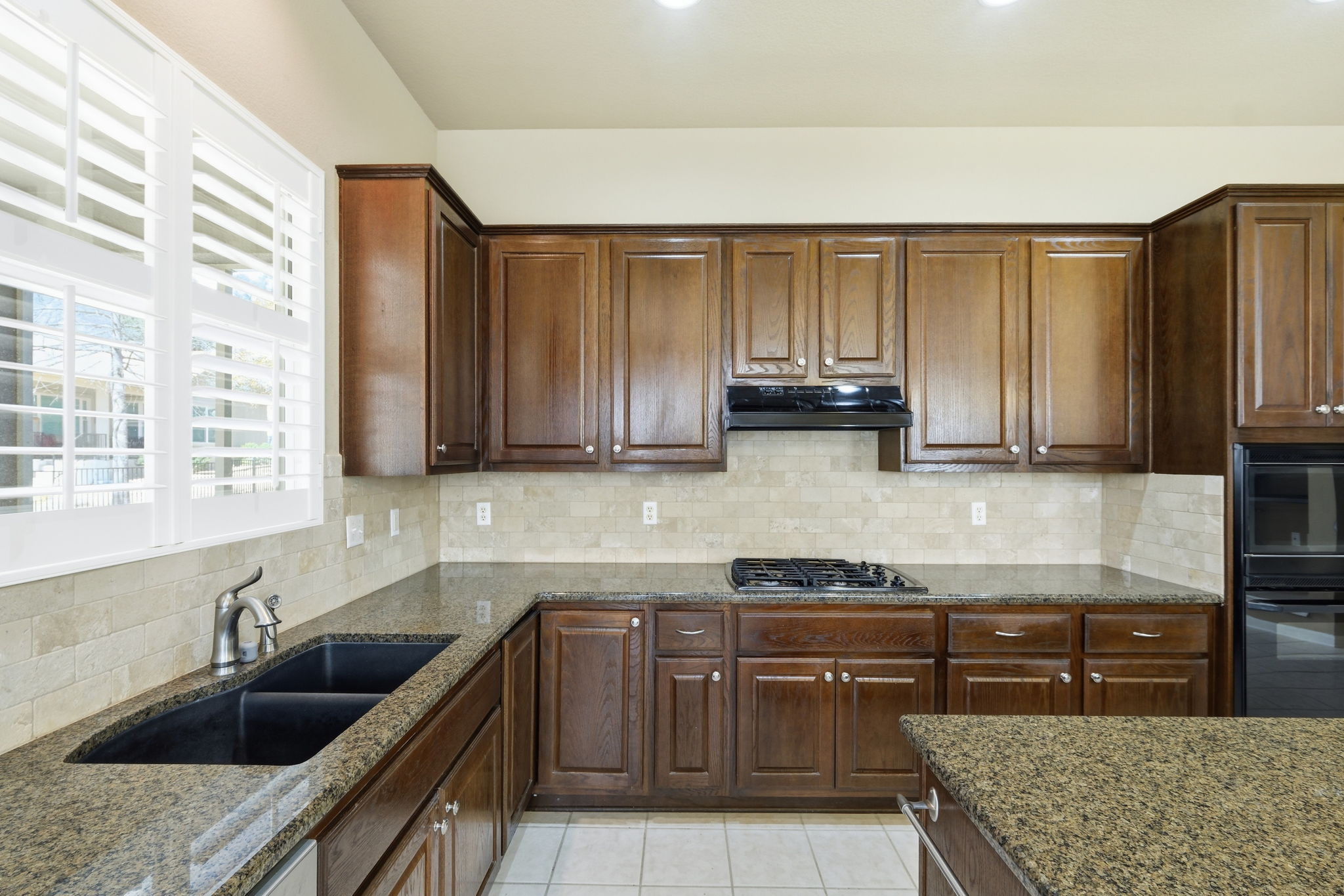 196 Whispering Wind Drive Georgetown, TX 78633 - Photo 11 of 34 a kitchen with kitchen island granite countertop a sink a counter space appliances and cabinets