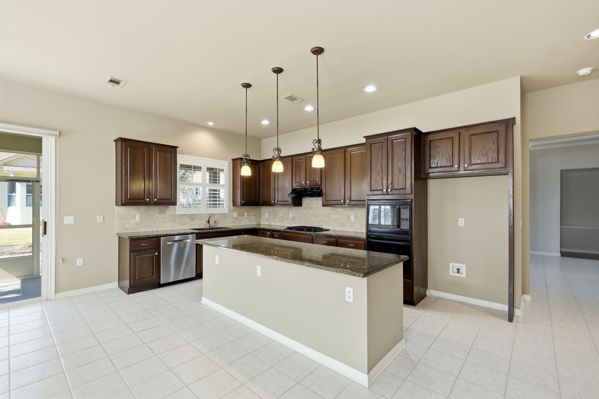 196 Whispering Wind Drive Georgetown, TX 78633 - Photo 9 of 34 a open kitchen with stainless steel appliances granite countertop a stove top oven a sink dishwasher a refrigerator and a oven with wooden floor