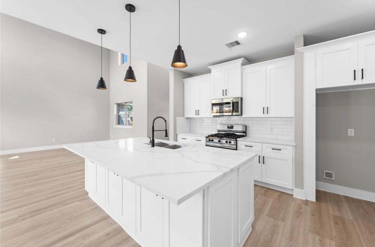 2518 Liguria Ln Spring Spring, TX 77388 - Photo 5 of 36 a kitchen with stainless steel appliances granite countertop a sink a stove a refrigerator and white cabinets with wooden floor