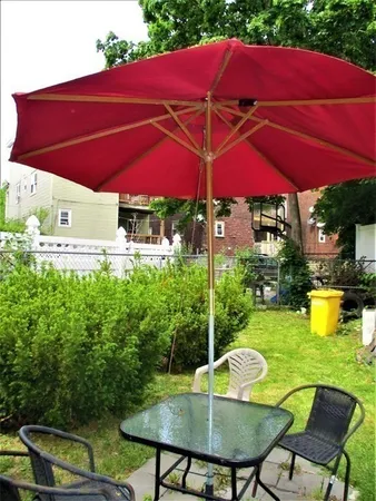 a view of pool with lawn chairs under an umbrella