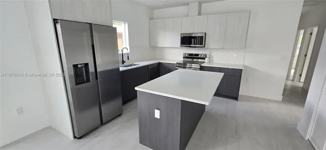 a kitchen with stainless steel appliances a refrigerator and a sink