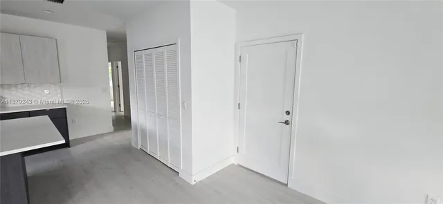 a view of a hallway with closet and a window