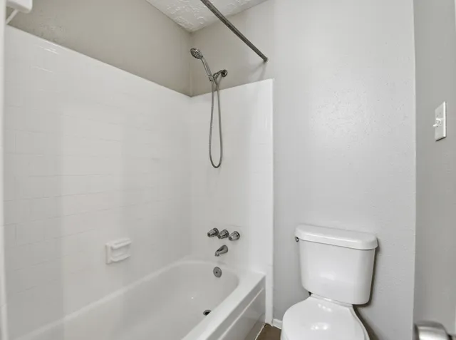 a bathroom with a toilet and a shower