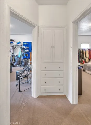 a bedroom with a bed and a dresser next to a window