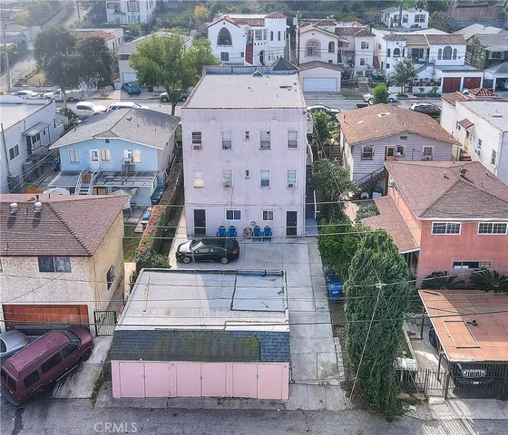 a front view of a building with cars parked
