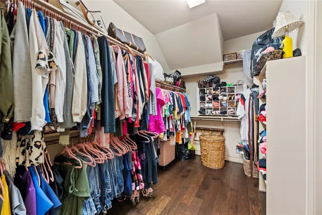 a view of walk in closet with clothes and shoes