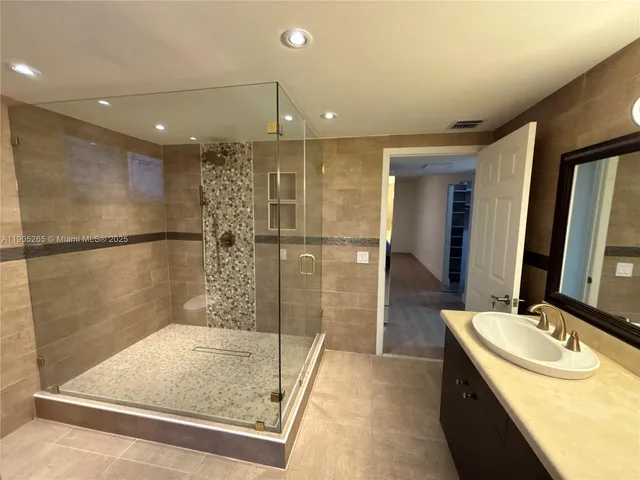 a bathroom with a glass shower door and a shower