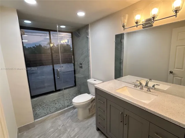 a bathroom with a sink vanity toilet and a mirror