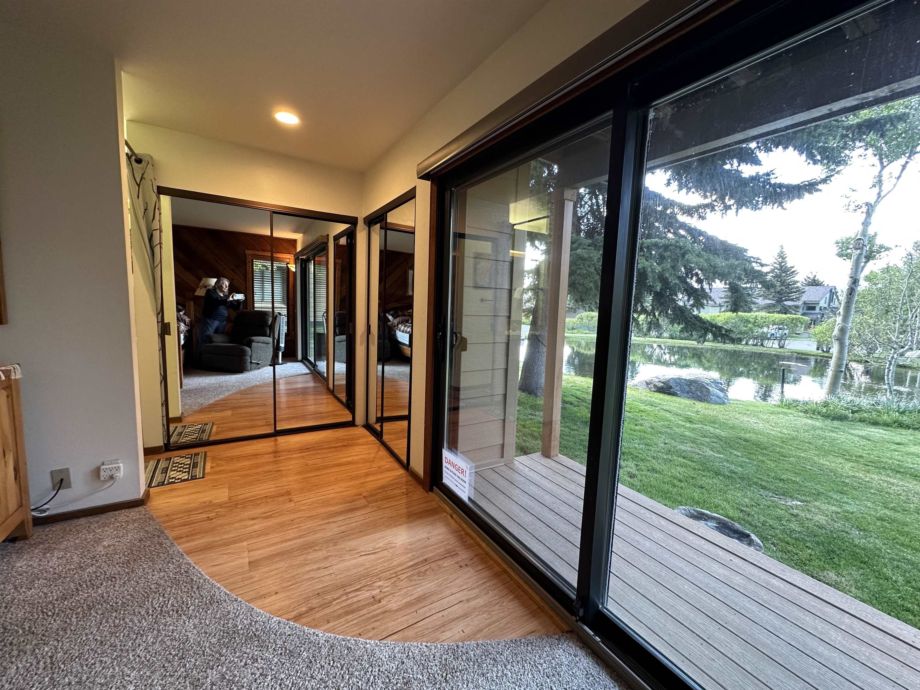 315 Fascination, Unit 315 Mammoth Lakes, CA 93546 - Photo 17 of 44 Outdoor decking with sliding glass door access, overlooking a tranquil pond