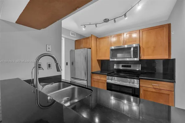 a kitchen with granite countertop a stove a sink and a microwave