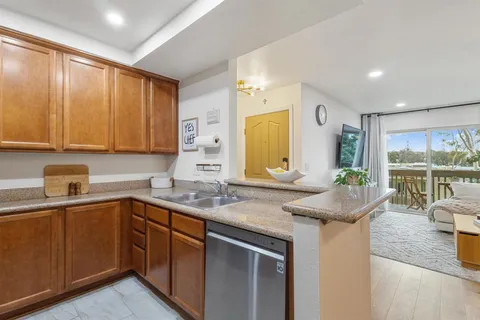 a kitchen with stainless steel appliances granite countertop a sink a stove and cabinets