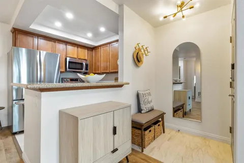 a kitchen with stainless steel appliances granite countertop a refrigerator a stove top oven a sink and dishwasher