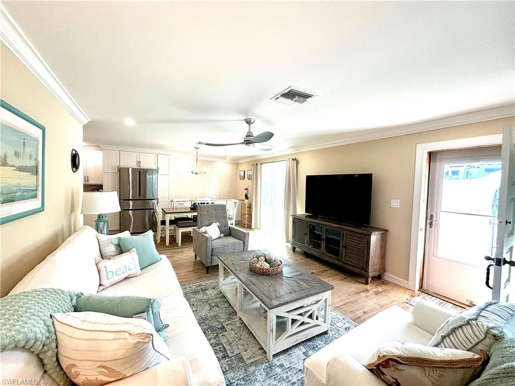 1435 Curlew Avenue, Unit 1 Naples, FL 34102 - Photo 1 of 19 a living room with furniture and a flat screen tv