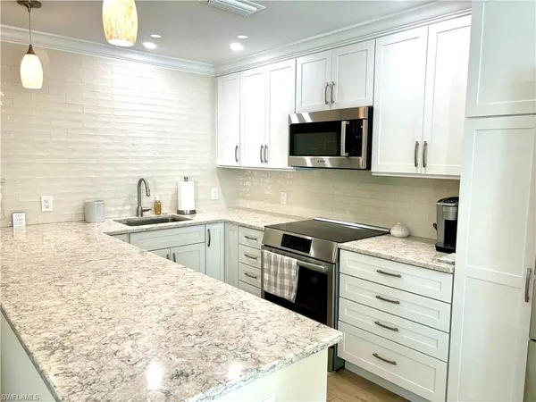 a living room with lots of furniture and view of kitchen