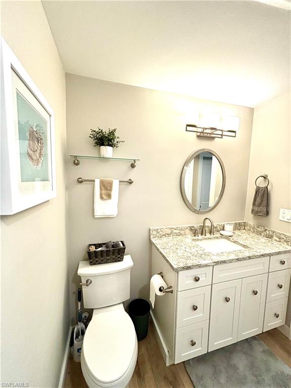 1435 Curlew Avenue, Unit 1 Naples, FL 34102 - Photo 5 of 19 a bathroom with a toilet a sink and a mirror