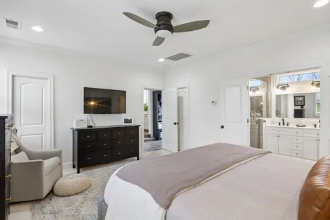 a spacious bedroom with a bed and a flat screen tv