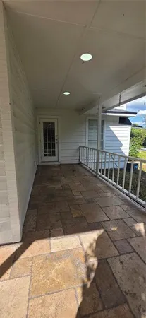 a view of an empty room with wooden floor a fireplace and a window
