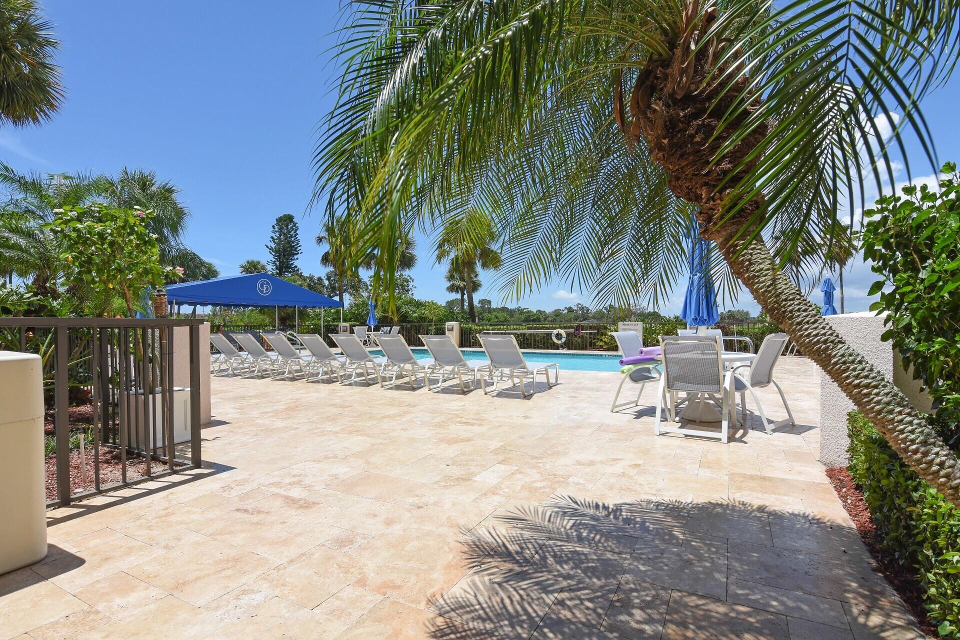356 Golfview Road, Unit 609 North Palm Beach, FL 33408 - Photo 56 of 104 a view of a backyard with a table and chairs under an umbrella with potted plants