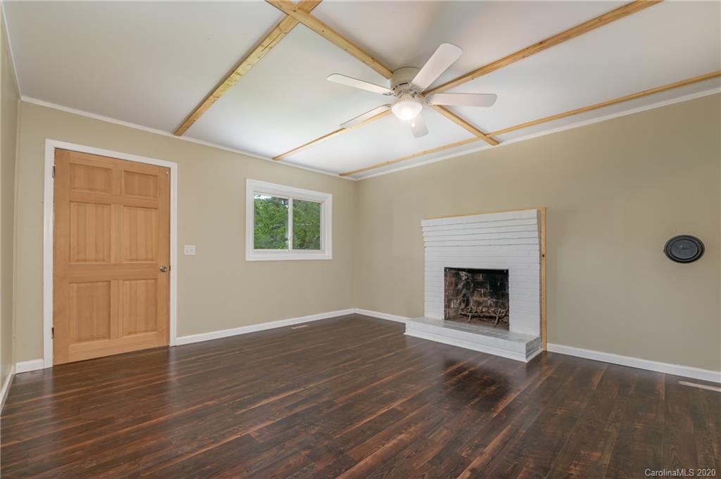 360 East 2nd Street Rutherfordton, NC 28139 - Photo 13 of 19 an empty room with wooden floor fireplace and windows