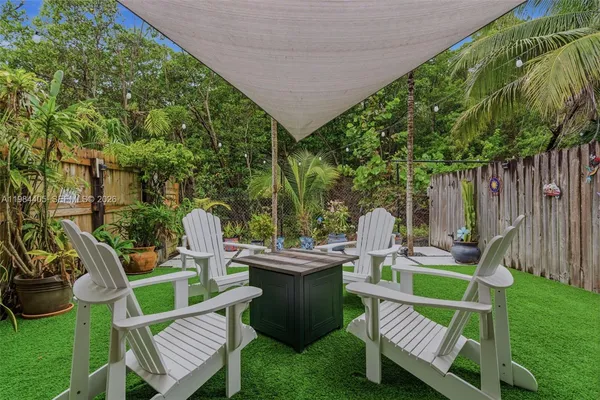 a view of a chair and table in backyard of the house