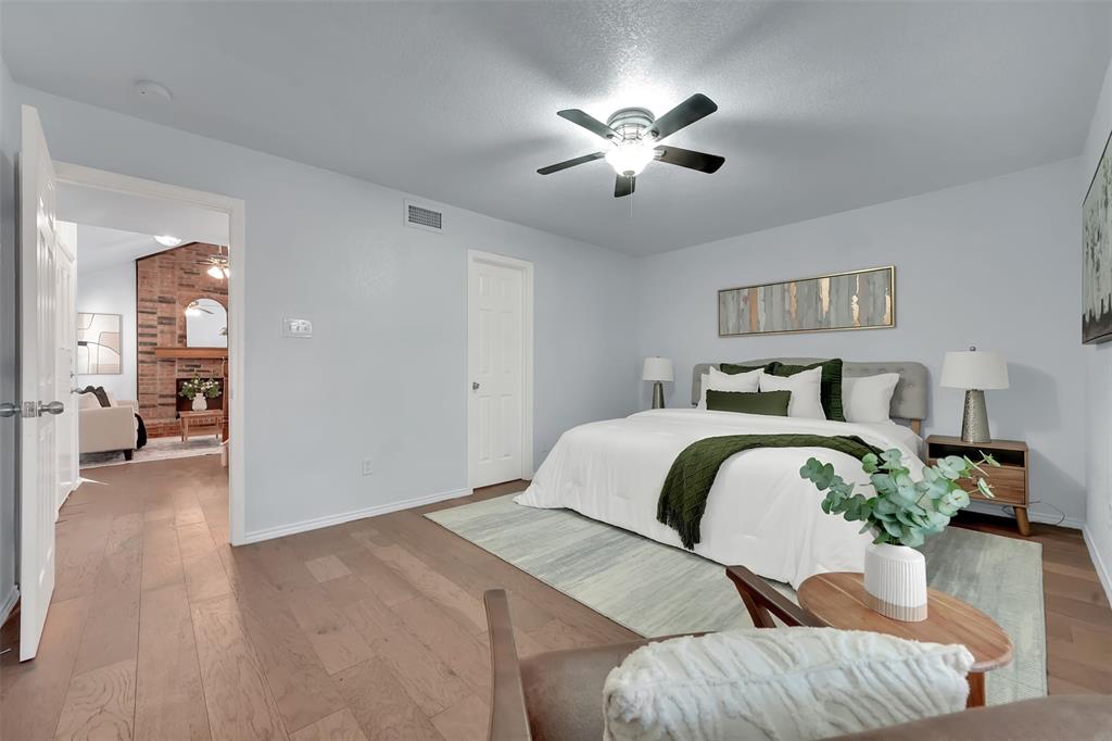 1024 East Peters Colony Road Carrollton, TX 75007 - Photo 24 of 38 Bedroom with light wood-type flooring, ceiling fan, a brick fireplace, and vaulted ceiling