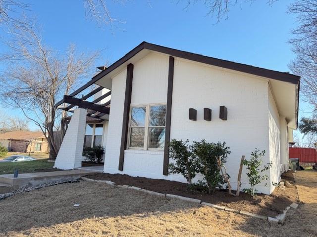 1024 East Peters Colony Road Carrollton, TX 75007 - Photo 35 of 38 View of side of home with brick siding, a pergola, and a patio