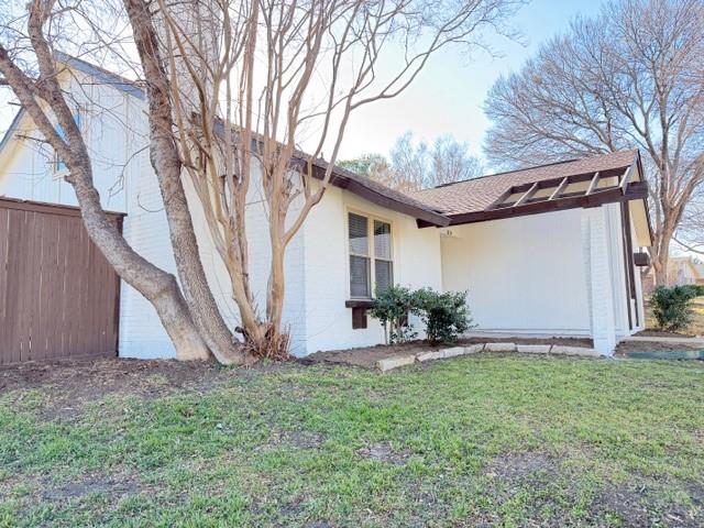 1024 East Peters Colony Road Carrollton, TX 75007 - Photo 5 of 38 View of property exterior featuring brick siding, a lawn, and roof with shingles