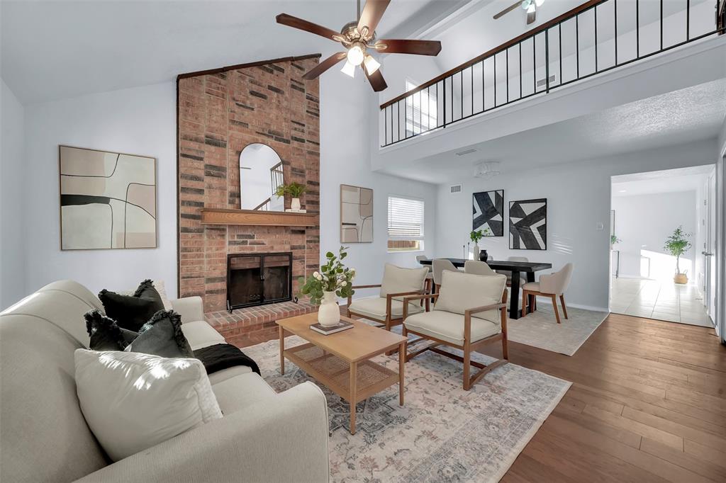 1024 East Peters Colony Road Carrollton, TX 75007 - Photo 6 of 38 Living area with a ceiling fan, wood finished floors, a brick fireplace, and lofted ceiling