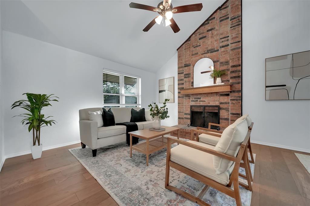 1024 East Peters Colony Road Carrollton, TX 75007 - Photo 7 of 38 Living room featuring lofted ceiling, a brick fireplace, hardwood / wood-style flooring, and a ceiling fan
