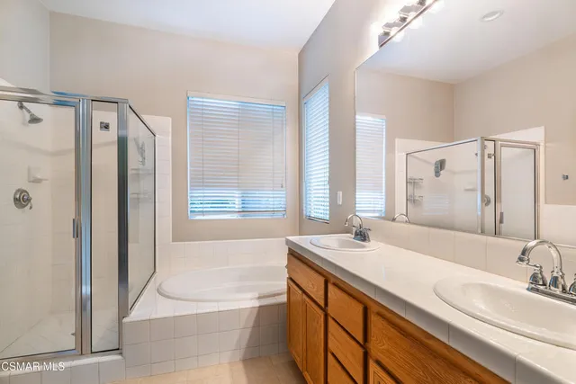 a bathroom with a tub sink and mirror