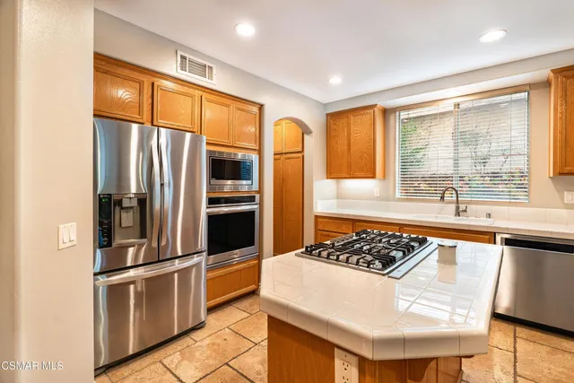 a kitchen with stainless steel appliances granite countertop a refrigerator and a stove