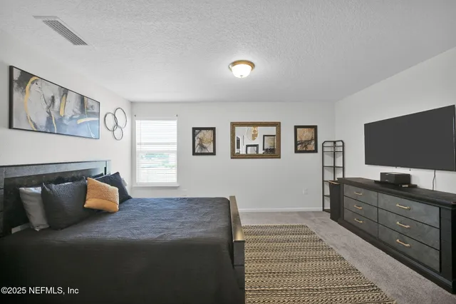 a bedroom with a bed and flat screen tv