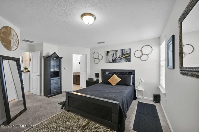 a bedroom with a bed and a mirror on the dresser