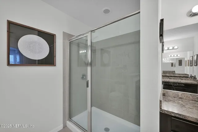a bathroom with a granite countertop bathtub shower sink and mirror