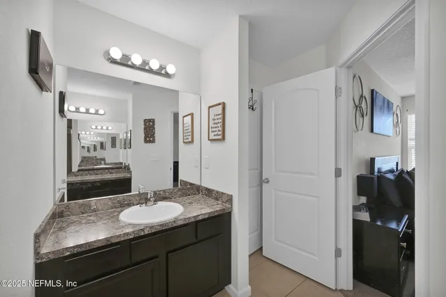 a bathroom with a granite countertop sink and a mirror