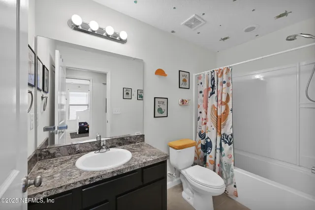 a bathroom with a granite countertop sink a toilet a mirror and shower