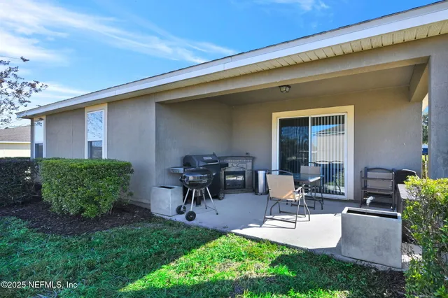 a view of backyard of house with outdoor seating and green space