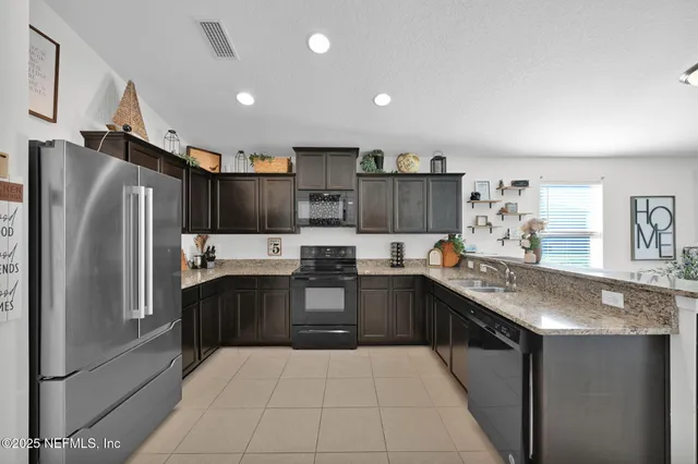 a kitchen with stainless steel appliances granite countertop a refrigerator and a sink