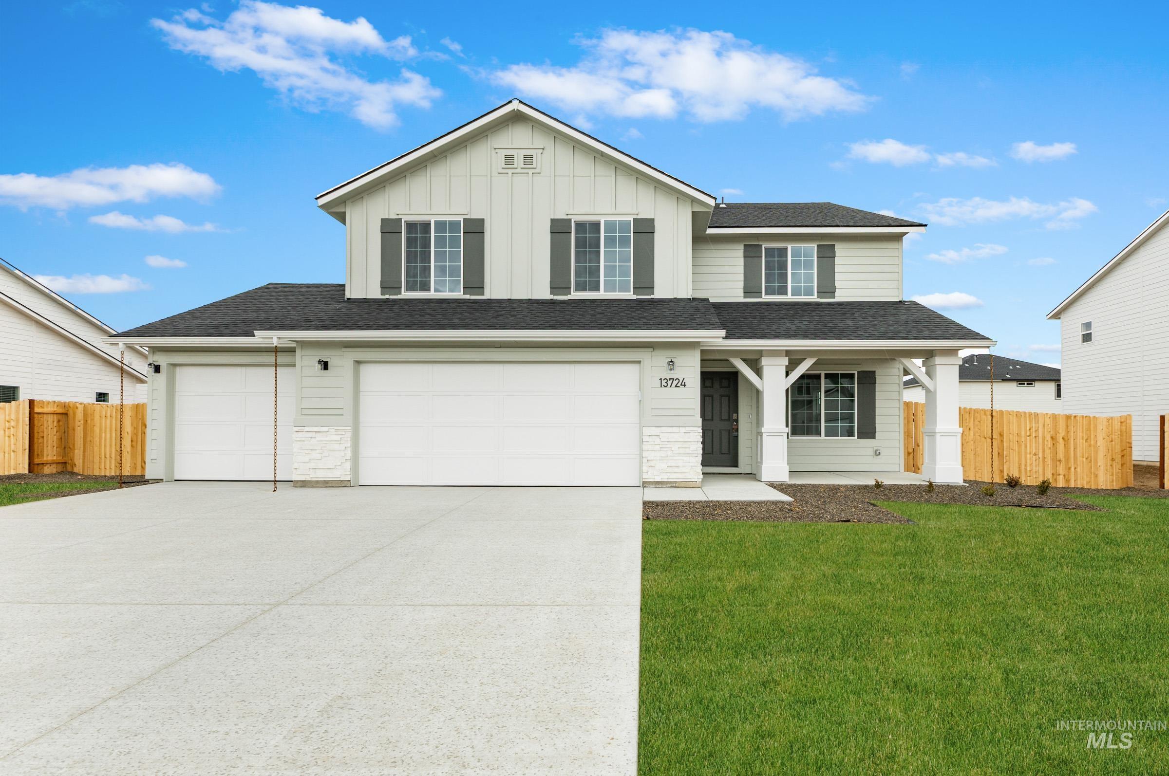 Traditional-style home with board and batten siding, driveway, roof with shingles, a porch, and a garage