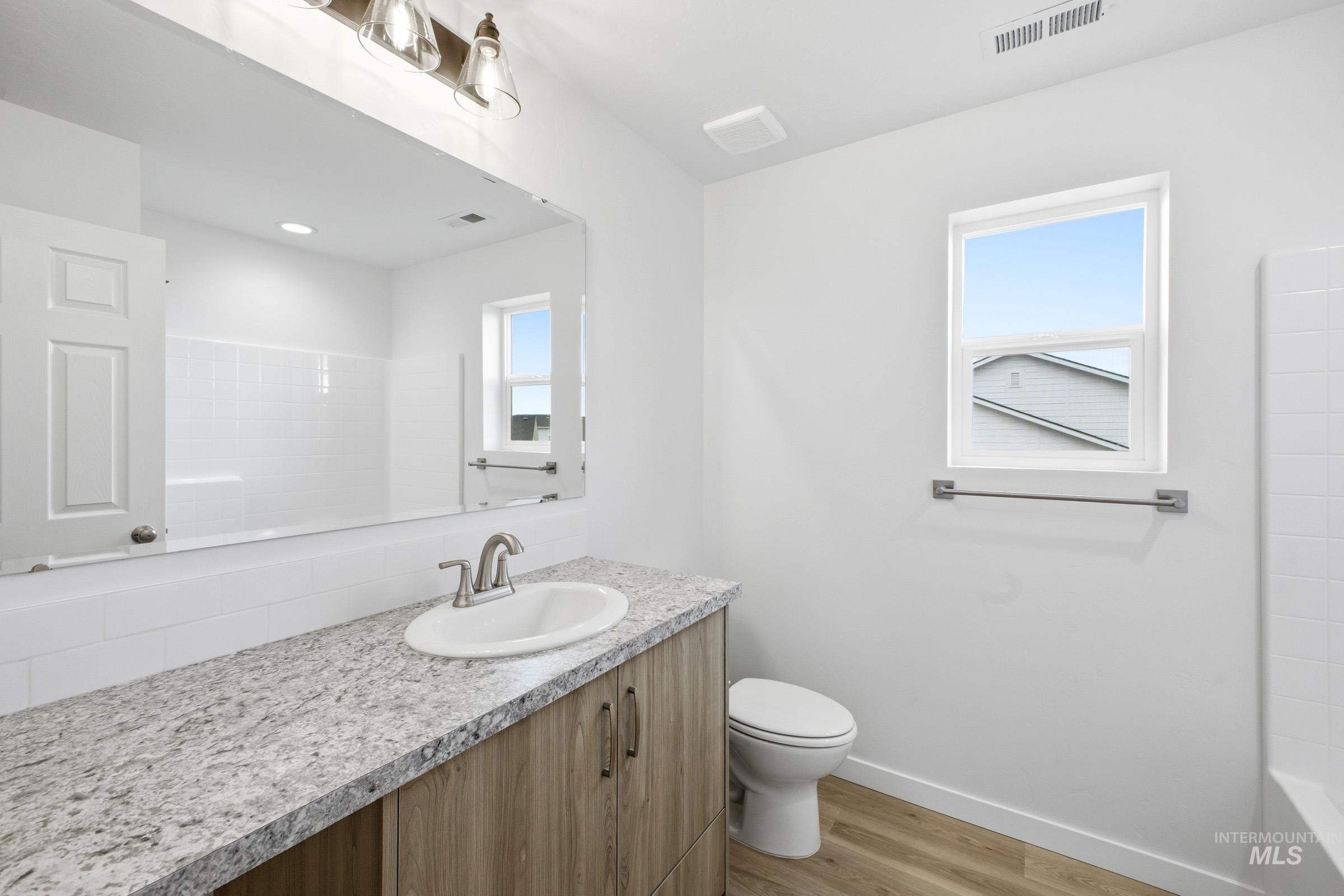 13724 Judson Street Caldwell, ID 83607 - Photo 17 of 23 Bathroom featuring vanity, light wood-type flooring, and shower / bathtub combination