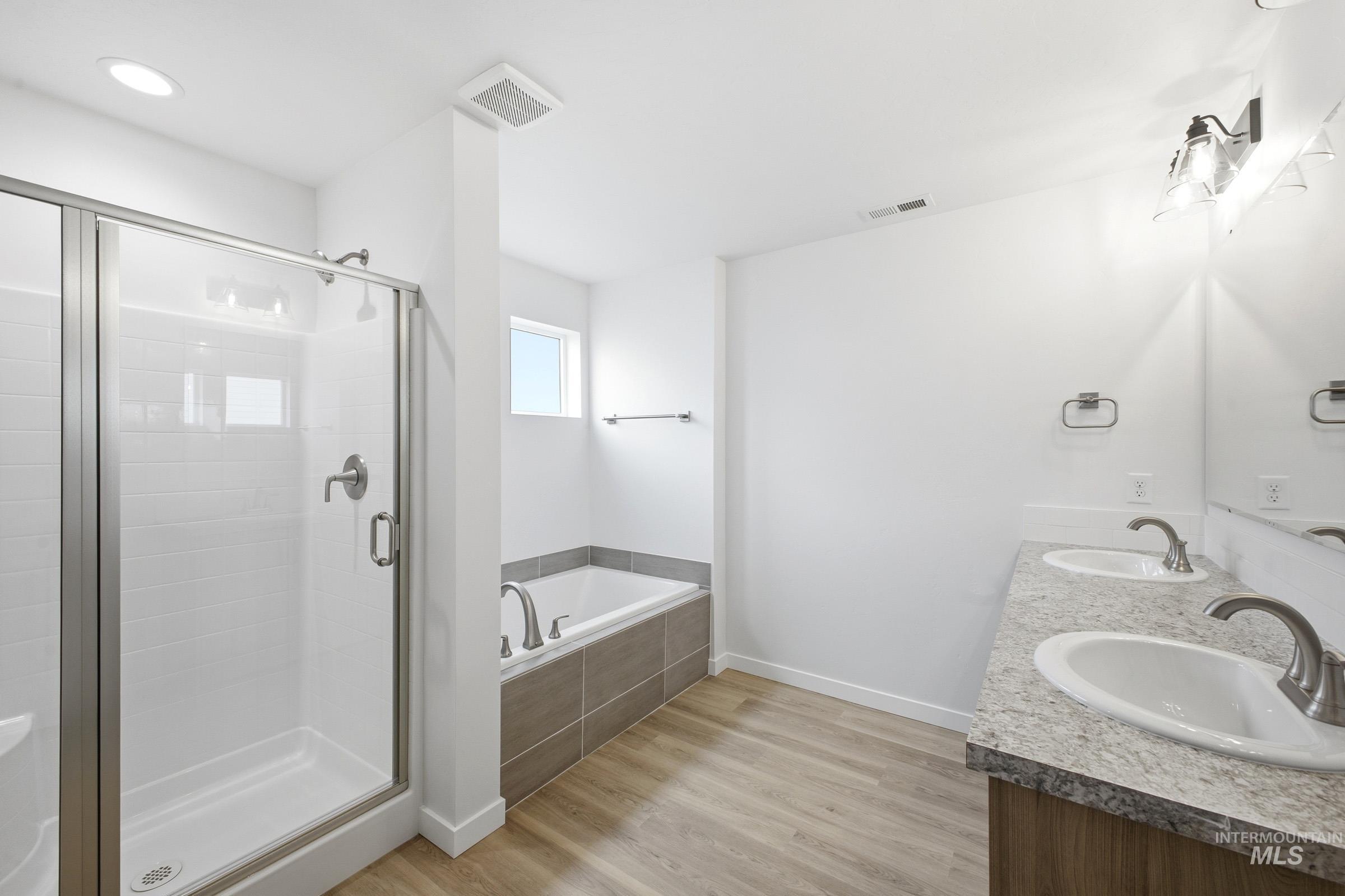 13724 Judson Street Caldwell, ID 83607 - Photo 20 of 23 Full bathroom featuring light wood-type flooring, double vanity, a bath, and a shower stall