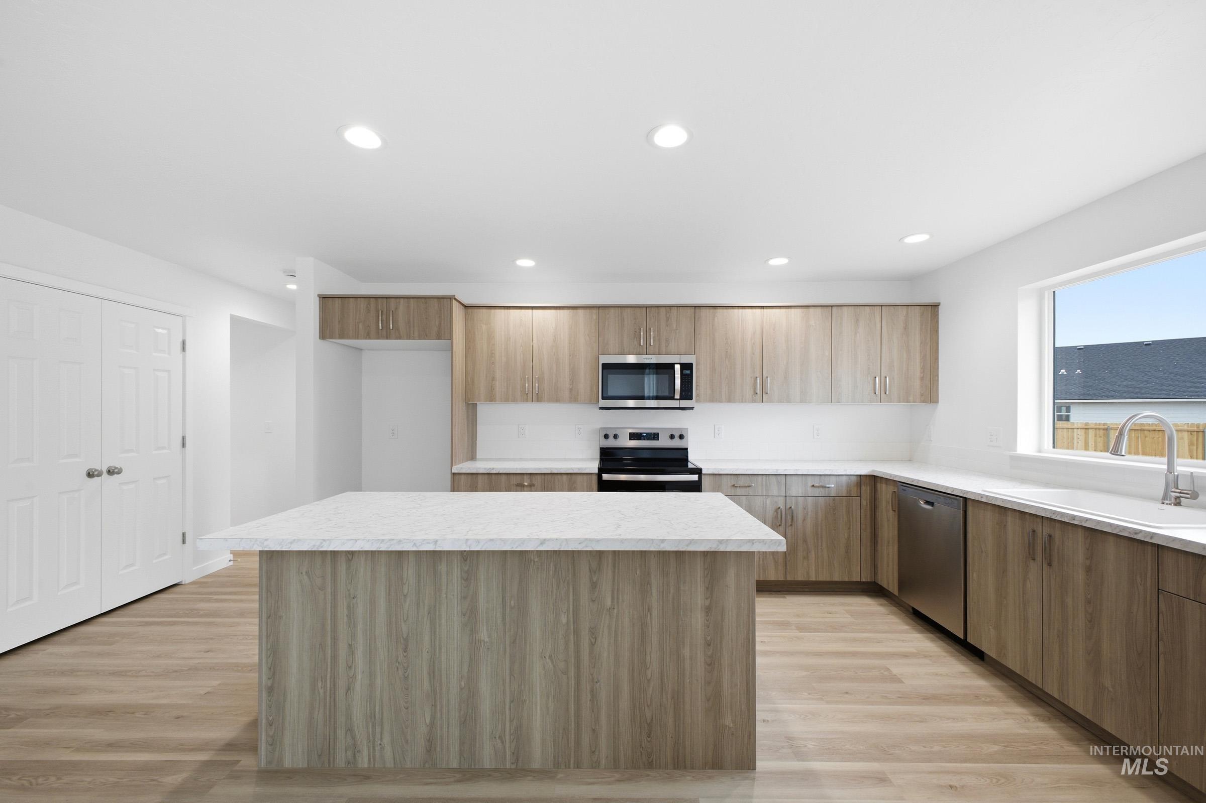 13724 Judson Street Caldwell, ID 83607 - Photo 4 of 23 Kitchen with light countertops, stainless steel appliances, modern cabinets, a center island, and light wood-style flooring