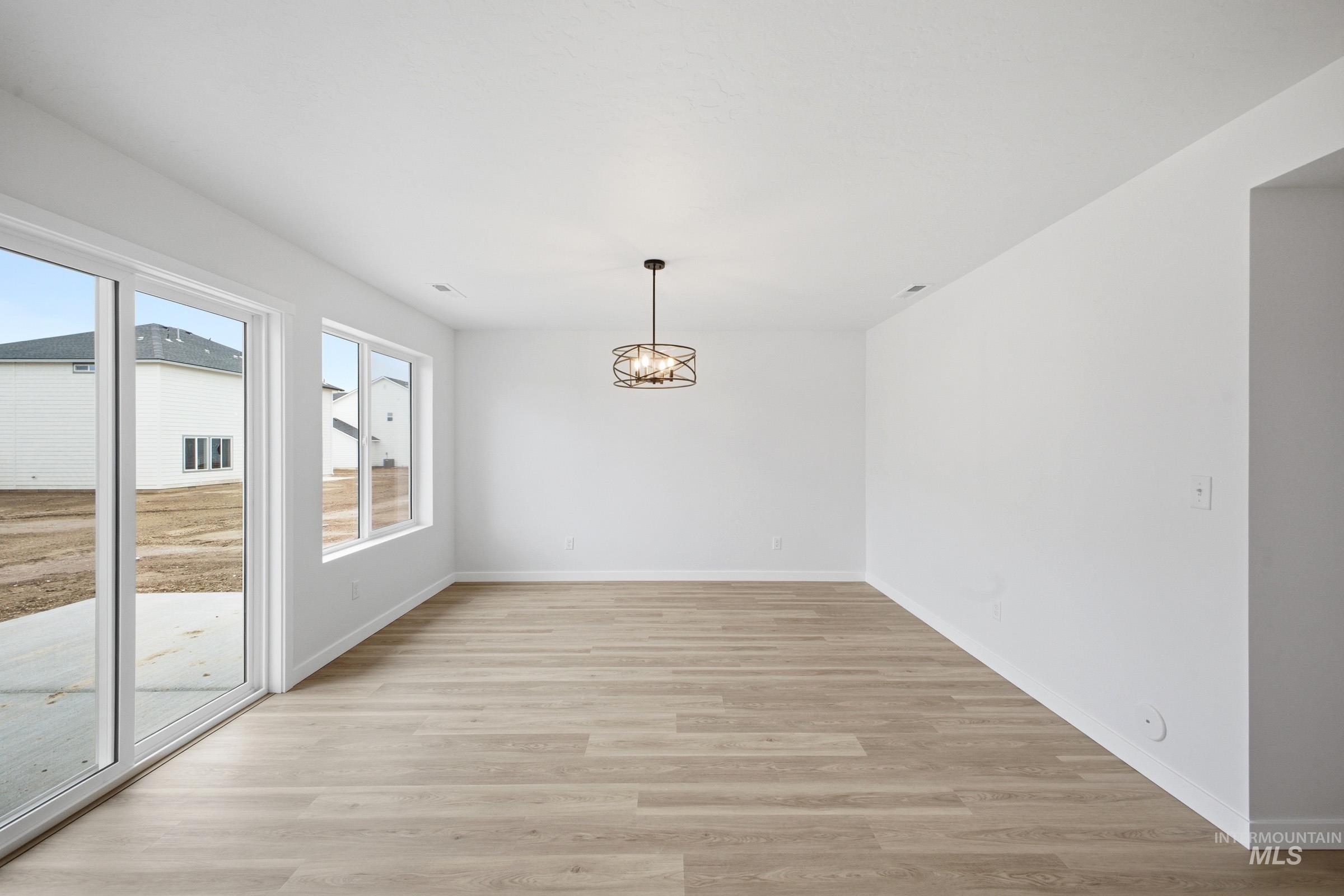 13724 Judson Street Caldwell, ID 83607 - Photo 6 of 23 Unfurnished dining area featuring light wood-style flooring and suspended lighting