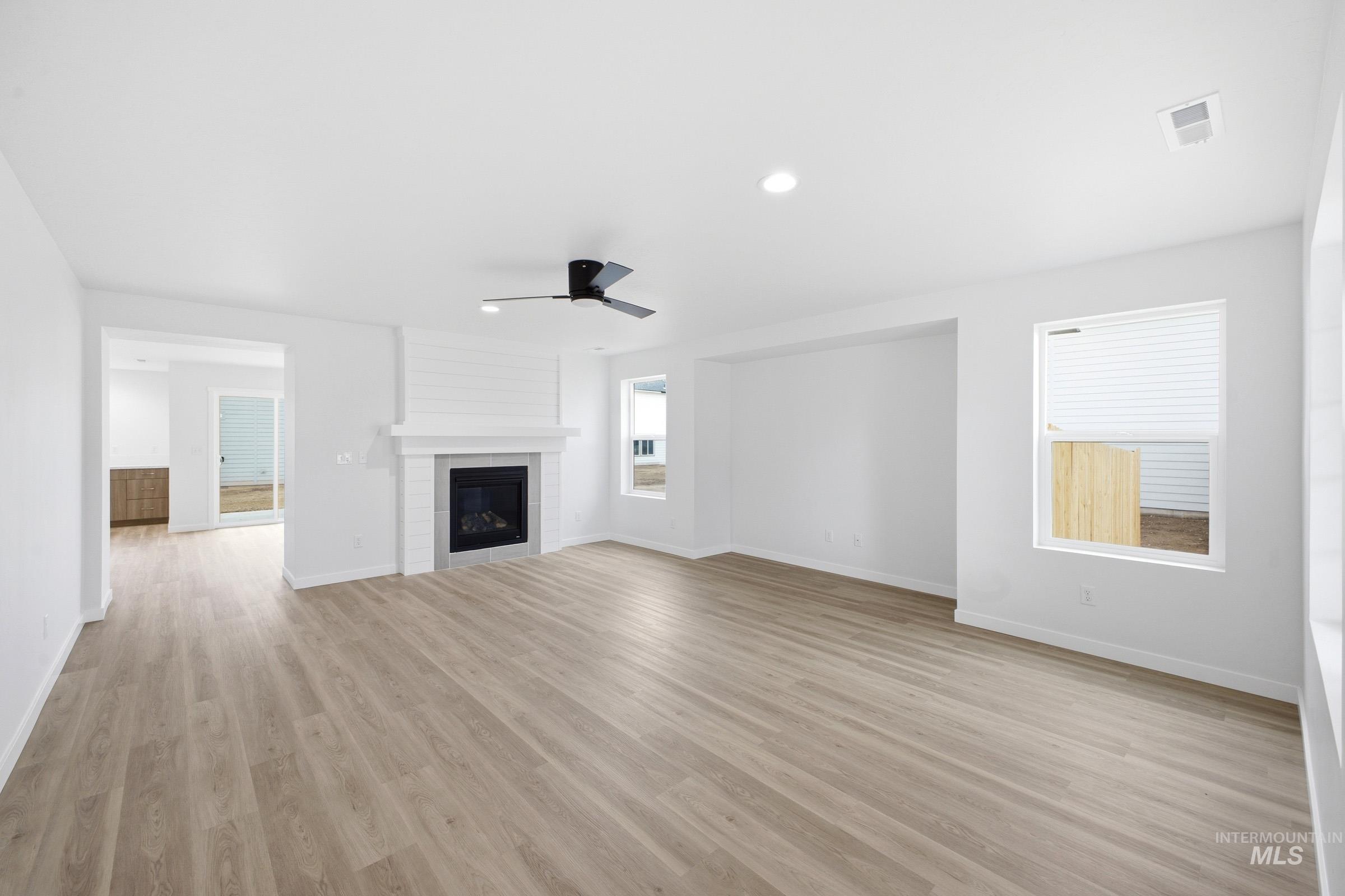 13724 Judson Street Caldwell, ID 83607 - Photo 7 of 23 Unfurnished living room featuring a fireplace, ceiling fan, light wood finished floors, and recessed lighting