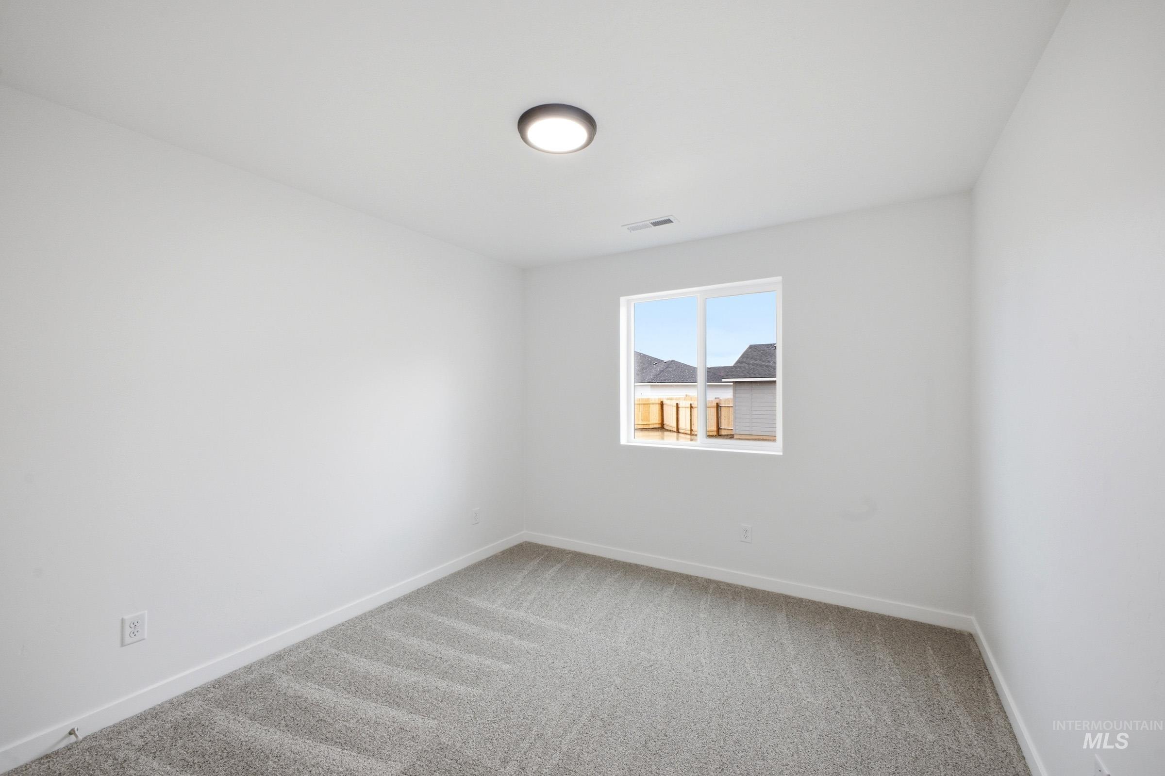 13724 Judson Street Caldwell, ID 83607 - Photo 9 of 23 Empty room with light colored carpet and baseboards