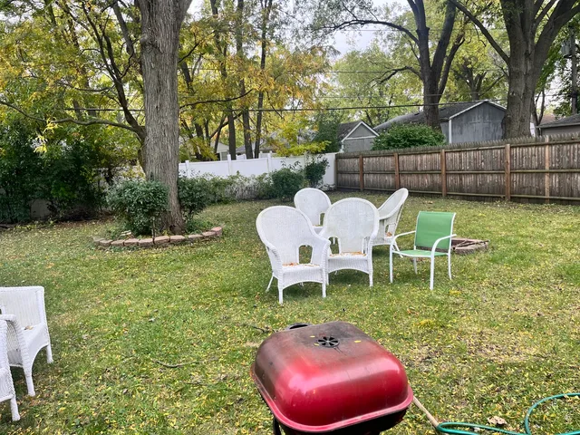 a view of a chairs and table in backyard
