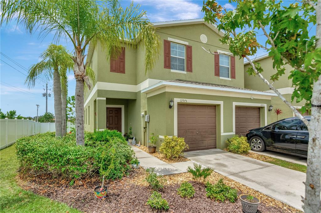 a front view of a house with a yard and potted plants