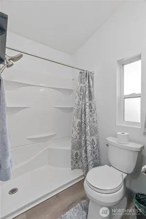 a white toilet sitting next to a bath tub