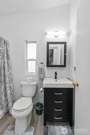a bathroom with a toilet a sink and mirror
