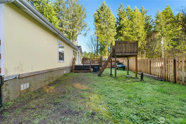 a view of backyard with wooden fence and a bench